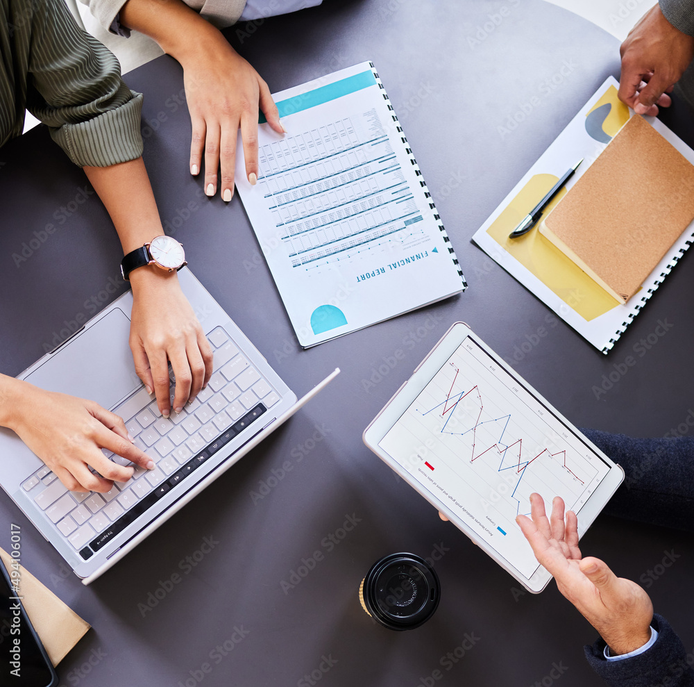Poster Tools and tricks of the trade. Shot of an office table with staff using a digital tablet and laptop.