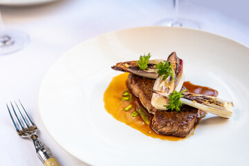 grilled steak with vegetables served in a restaurant on white linnen close up