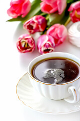Romantic morning cup of tea. Bouquet pink tulip. Selective focus.