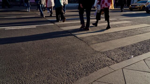 Urban landscape, people crossing the roadway at a pedestrian crossing.