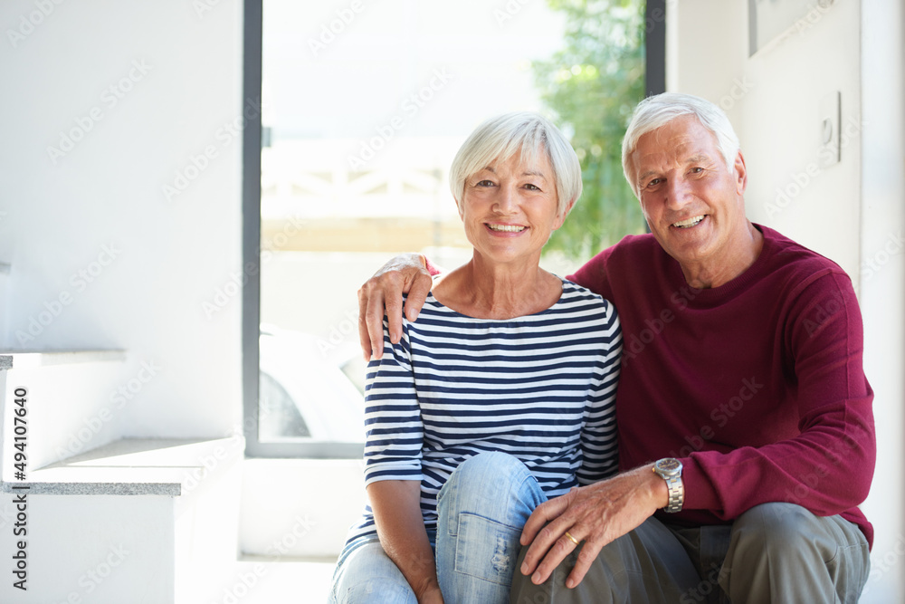 Wall mural Their love is strong. Portrait of a loving senior couple sitting together at home.