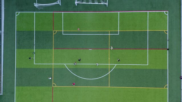 Aerial Top Down View of Soccer Field. Aerial football match play. Clip. Aerial shot Two teams playing ball in football outdoors, top view. Football game outdoors, green field with markings. 