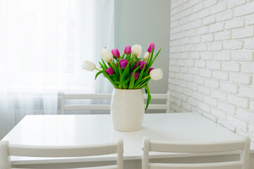 Bouquet of purple and white tulips on the kitchen table