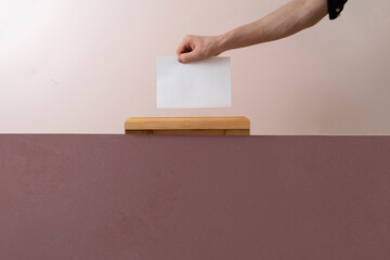 a voter hand put paper in the urn, democracy election