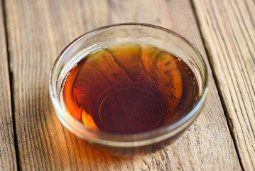fish sauce on glass bowl and wooden background, fish sauce obtained from fermentation fish or small aquatic animal, fermented foods