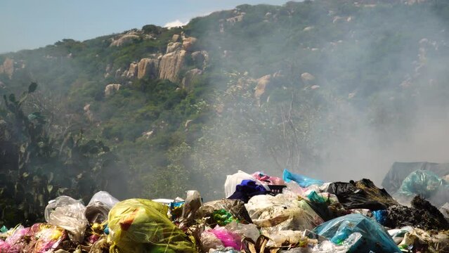 Close up shot of burning  trash,plastic and garbage in Vietnam during summer.Environmental air pollution with nature in background.Destroying Environment. Save the planet