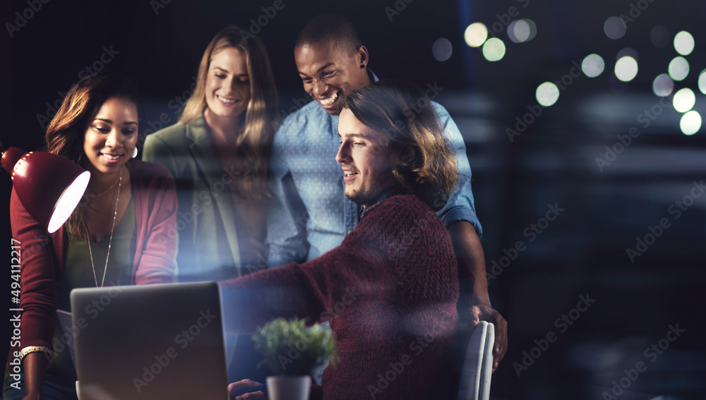 Poster teamwork and dedication. shot of a group of colleagues working late in the office together.