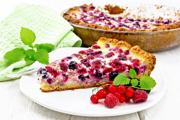 Pie with raspberries and currants in plate on board
