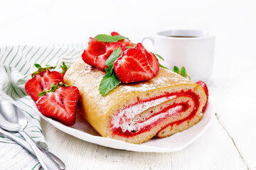 Roll with cream and strawberries in plate on white board