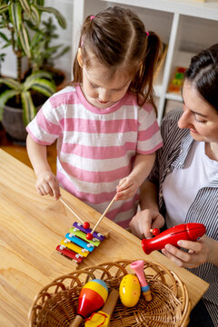 Montessori material. Home education. Mom and daughter are learning musical instruments.