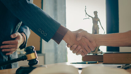 Businessmen shake hands to seal an agreement with lawyers discussing contract agreements male lawyer judges Legal Consultation Contract consulting services to plan a hammer-forward court case