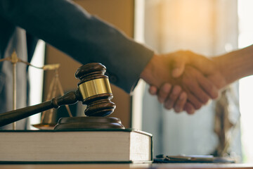 Businessmen shake hands to seal an agreement with lawyers discussing contract agreements male lawyer judges Legal Consultation Contract consulting services to plan a hammer-forward court case