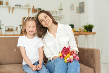 Lovely home portrait of mother and daughter or nanny and little girl.