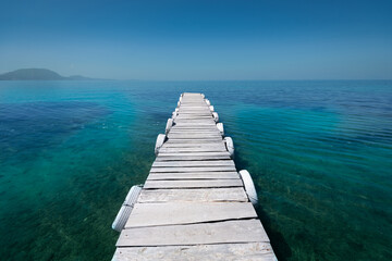 White old wooden pier on the seashore on a beautiful sunny day. Corfu Greece