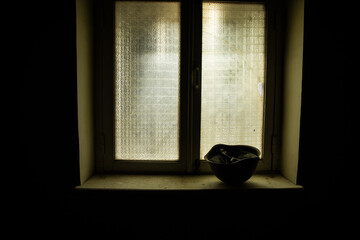 Conceptual photo of war between Russia and Ukraine. Ukraine and Russia flags on windowsill at...