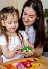 Montessori material. Mom and daughter learn colors. Wooden toy cars.