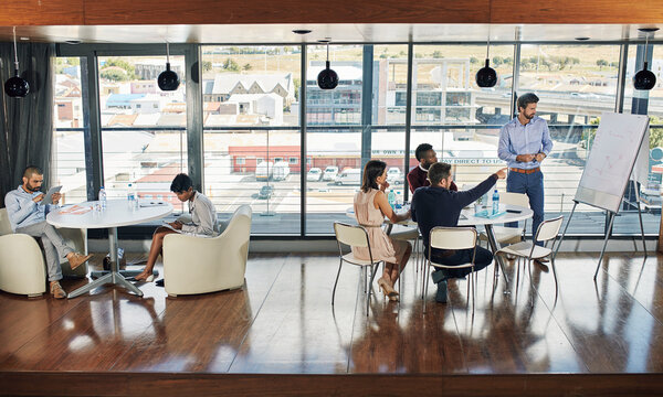 Many functions for one room. Full length shot of a young businessman giving a presentation.