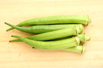 Raw green okra on wooden table