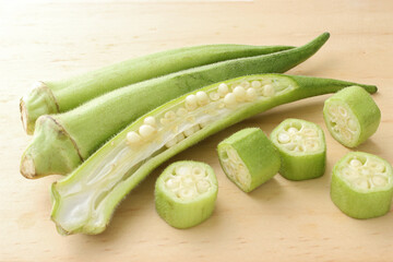 Raw green okra sliced ​​on wooden table