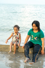 Children playing sand together. Asian little kids playing at the beach.