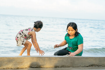 Children playing sand together. Asian little kids playing at the beach.