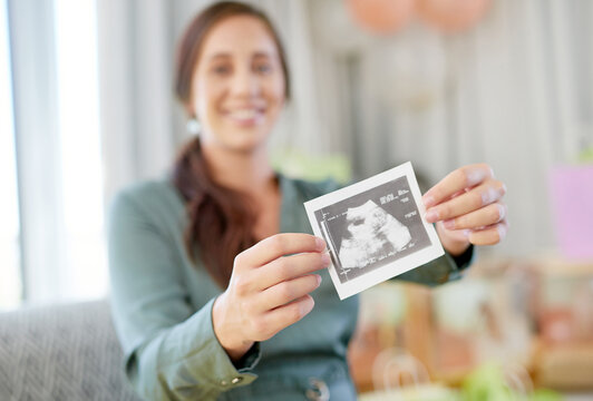 9 months of pure joy. Shot of a young mother to be holding an ultrasound of her unborn child.