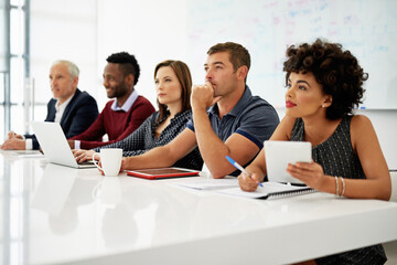 This presentation has got them thinking. Cropped shot of a group of businesspeople listening to a presentation in an office.