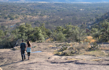 a couple walking hand in hand down a rock slope