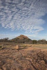 pink granite landscape under and blue sky dotted with puffy clouds