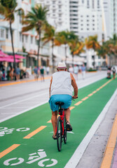 Obraz premium old man on bike ocean drive Miami Beach florida sport lifestyle road street 