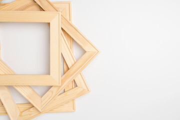A stack of wooden stretchers for canvas stretching in a baguette workshop on a white background....