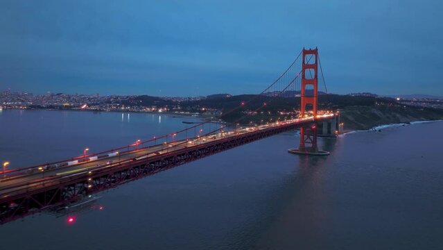 Establishing aerial San Francisco Skyline and illuminated red Golden Gate Bridge