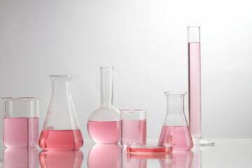 Front view of laboratory equipment filled with pink fluid in a beaker test tube in lab background...
