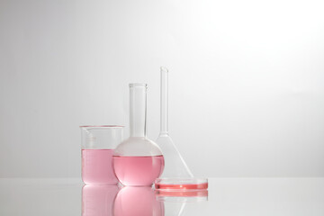 Front view of laboratory equipment filled with pink fluid in a beaker test tube in lab background...