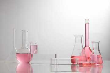 Front view of laboratory equipment filled with pink fluid in a beaker test tube in lab background for experiment advertising 