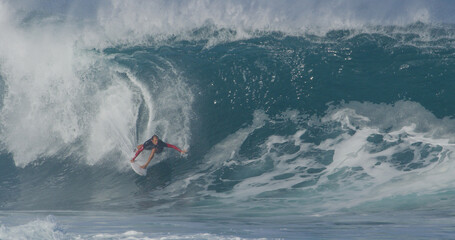 Surfer surfing big wave barrel tube pro surfer Tyler Newton