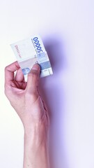 Indonesian Rupiah the official currency of Indonesia. Man's hand is making a payment. Male hand showing Indonesian Rupiah Note. Business Investment Economy and Finance Concept Uang 50000 50.000 Rupiah