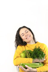 Smiling woman with apples, celery and dill with parsley. Spring and vitamins. The concept of healthy nutrition. Front photo.