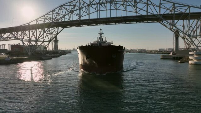 Aerial reveal of a tanker heading out from the port of Corpus Christi, Texas.