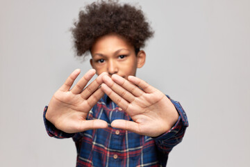 Selective focus on opened palms of African American boy with afro hairstyle showing stop sign...