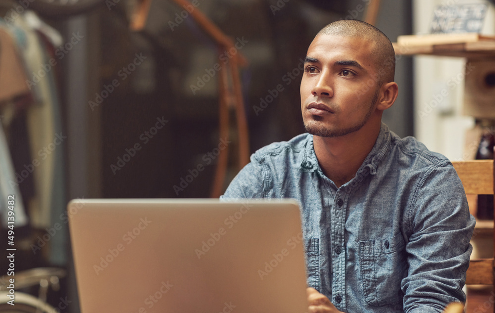 Poster his store is wifi enabled. shot of a young man using a laptop in a cafe.