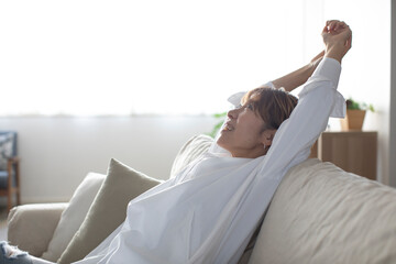 ソファでくつろぐミドル世代の日本人女性