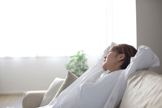 ソファでくつろぐミドル世代の日本人女性