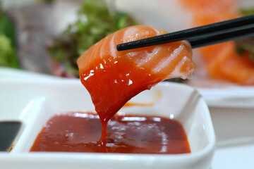 dip salmon sashimi in red chili-pepper paste.