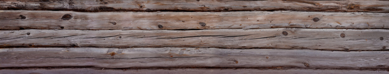 Background of a wall folded from old massive cracked logs