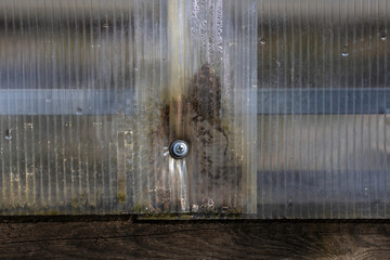 Close-up of incorrect fastening of a polycarbonate sheet. Damaged polycarbonate sheet due to...
