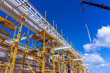Naklejka premium building construction site with yellow scaffolding , Installation Roof Steel structure