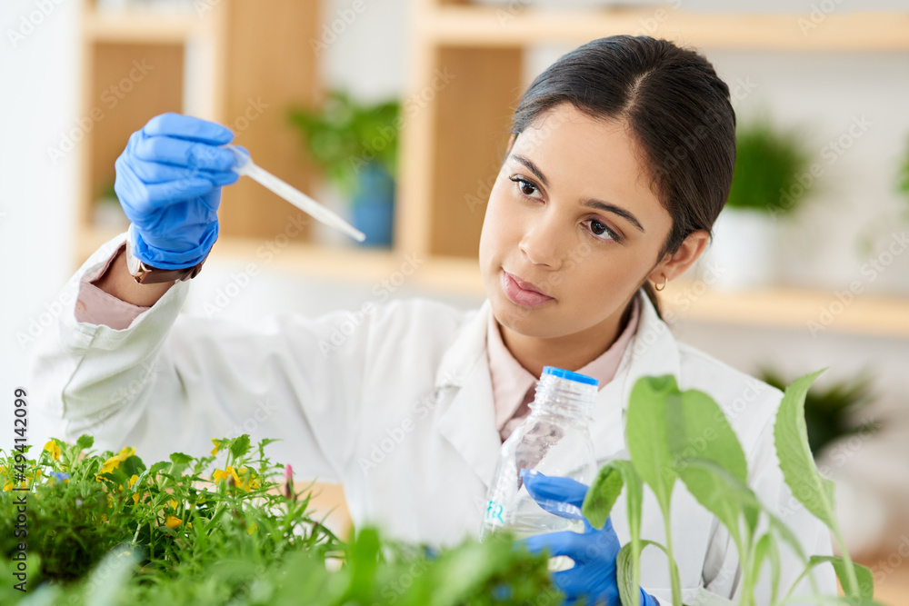 Poster just a drop will do. shot of a young scientist working with plant samples in a lab.