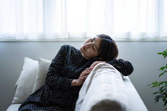 ソファでくつろぐミドル世代の日本人女性
