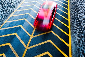 The car is driving on a road with a linear background